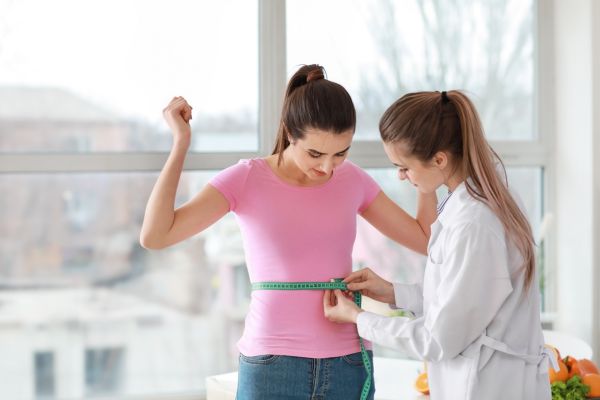 Measuring Waist of Young Woman in Weight Loss Clinic